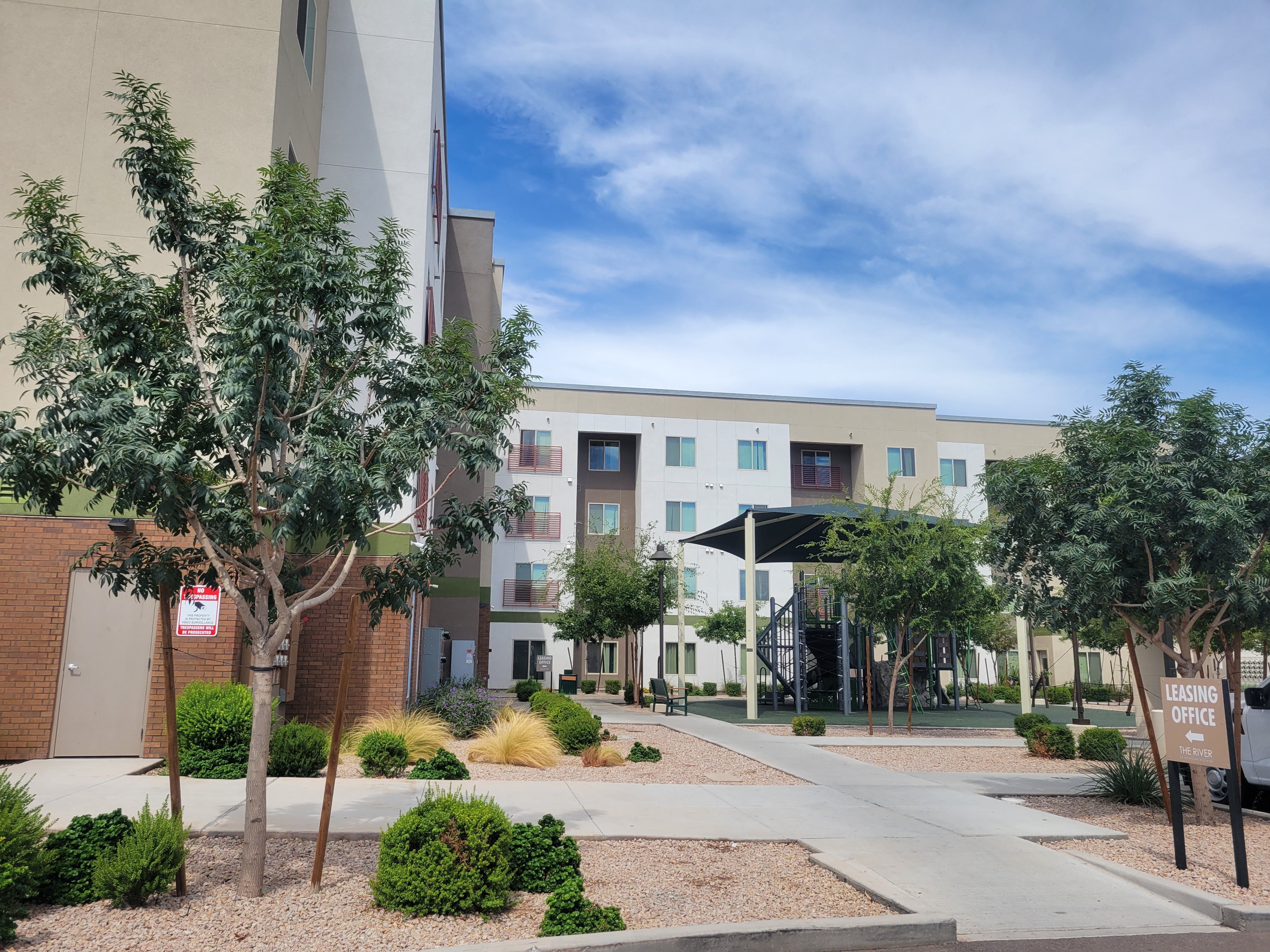 an exterior view of a building with trees and a sidewalk